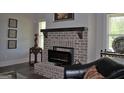 Cozy living room featuring a brick fireplace and dark hardwood floors at 808 Covered Bridge Rd, Covington, GA 30016