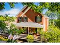 Charming red brick two-story home with a welcoming front porch and well-manicured landscaping at 1295 Heritage Dr, Villa Rica, GA 30180