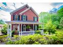 Charming two-story brick home with a welcoming front porch and well-maintained landscaping at 1295 Heritage Dr, Villa Rica, GA 30180