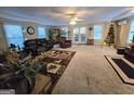 Cozy living room with large windows, a ceiling fan, and an inviting Christmas tree in the corner at 110 Kari Glen Way, Fayetteville, GA 30215