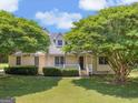 Charming home with a well-manicured lawn and mature trees surrounding the property at 105 Birch Creek Cir, Mcdonough, GA 30253