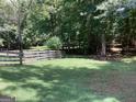 Expansive backyard with a manicured lawn, wooden fence, and mature trees, providing a private setting at 857 Cooper Rd, Social Circle, GA 30025
