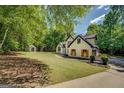 Charming white brick home with black trim and wood shutters with a large yard at 857 Cooper Rd, Social Circle, GA 30025