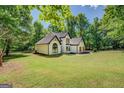 Charming white brick home with black trim and wood shutters with a large yard at 857 Cooper Rd, Social Circle, GA 30025