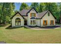 Beautiful two-story home with a manicured lawn, striking black trim, and rustic wooden shutters at 857 Cooper Rd, Social Circle, GA 30025