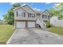 Charming two-story home featuring a two-car garage, landscaped yard, and inviting front entrance at 1341 Huey Rd, Douglasville, GA 30134