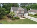 An aerial view of a two-story home with a manicured lawn and mature trees surrounding the property at 243 Kensington Trce, Stockbridge, GA 30281