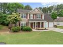 Charming two-story home featuring a landscaped front yard, red shutters, and a two-car garage at 243 Kensington Trce, Stockbridge, GA 30281