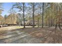 A distant view of a charming home nestled among tall trees, highlighting the property's privacy at 1234 Coweta Heard Rd, Hogansville, GA 30230