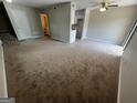 Open-concept living room and kitchen area with new carpet and a ceiling fan at 1466 Pine Log Ne Rd # A, Conyers, GA 30012