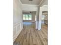 Bright foyer featuring hardwood floors, white trim, and an open floor plan to the dining and living spaces at 1715 Crumbley Rd # 2, Mcdonough, GA 30252