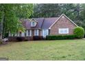 Classic brick house with mature trees and well-kept front yard at 8039 Woods Ln, Jonesboro, GA 30236