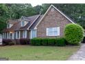 Attractive brick home with manicured bushes and a lush green lawn at 8039 Woods Ln, Jonesboro, GA 30236