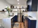 Modern kitchen features navy cabinets, stainless steel appliances, granite countertops, and stylish open shelving at 95 Mccoy Dr, Carrollton, GA 30116