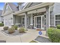 Charming covered porch with stone accents, gray columns, and tasteful landscaping create curb appeal at 70 Pacific Ave, Sharpsburg, GA 30277