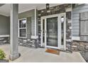 Closeup of a covered entryway boasting stone accents, a stylish front door, and neutral color palette at 70 Pacific Ave, Sharpsburg, GA 30277