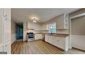 Bright kitchen features white cabinets, stainless steel appliances and wood floors at 11953 Brown Bridge Rd, Covington, GA 30016