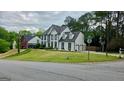 Suburban home featuring a three-car garage on a well-manicured corner lot at 303 Sedgewick Trl, Lawrenceville, GA 30044