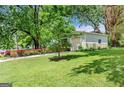 Exterior view of a home highlighting the lawn, driveway, and garage with adjacent flowerbeds and a partial fence at 2364 Woodside Way, Atlanta, GA 30341