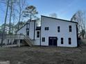 Back exterior showing deck, dual door access, and windows in a wooded lot at 783 Lost Creek Cir, Stone Mountain, GA 30088