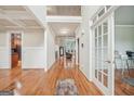 Bright hallway with gleaming wood floors and coffered ceilings, offering a view of the home's layout at 1979 Alcovy Shoals Blf, Lawrenceville, GA 30045
