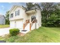 Charming two-story home with a two-car garage and inviting entrance with wood and black trimmed steps at 5582 Rockingwood Ct, Atlanta, GA 30349
