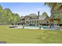 Backyard features a large pool, hot tub, screened in porch, pergola, and expansive green lawn at 310 Westbourne Dr, Tyrone, GA 30290