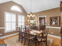 Elegant dining room with large windows, chandelier, and hardwood floors and adjacent kitchen at 1466 Lake Forest Ln, Mcdonough, GA 30253