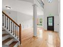 Bright foyer featuring gleaming hardwood floors, staircase, and a view of the second story landing at 7020 Grand View Way, Suwanee, GA 30024