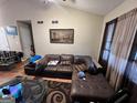 Spacious living room with hardwood floors, a large leather sofa, and a modern area rug at 177 Villa Rosa Way, Temple, GA 30179