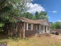 Side view of brick home featuring a covered front porch with stairs leading to the entrance at 13090 Brown Bridge Rd, Covington, GA 30016