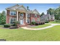 Beautiful brick home with lush green lawn and mature trees in a quiet neighborhood at 3183 Jackson Creek Dr, Stockbridge, GA 30281