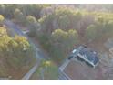 An aerial view showing a home with a yard and driveway in a wooded neighborhood at 323 Nicole Dr, Temple, GA 30179