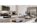 Modern kitchen featuring granite countertops, stainless steel appliances, and stylish fixtures at 346 Friendship Oak Way, Hampton, GA 30228