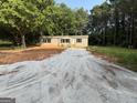 A single-story home features fresh gravel driveway, tan siding, and black shutters at 30 Alyssa Ln, Bowdon, GA 30108