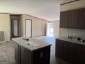 Open kitchen with island, ample counter space, and modern finishes in neutral tones at 30 Alyssa Ln, Bowdon, GA 30108