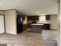 Open kitchen featuring an island, dark wood cabinets, and modern appliances at 30 Alyssa Ln, Bowdon, GA 30108