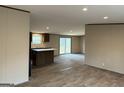 Open living room flows into kitchen, with wood-look floors and natural light from sliding glass door at 30 Alyssa Ln, Bowdon, GA 30108