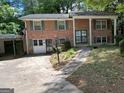 Traditional two-story brick home with green shutters and a mature landscaped front yard at 2425 Wood Valley Dr, Morrow, GA 30260