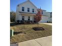 Lovely two-story home showcasing manicured landscaping, charming front porch, and attached two car garage at 136 Paulownia Cir, Mcdonough, GA 30253