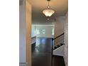 Inviting foyer features dark wood floors, staircase, and an open view to the living area at 136 Paulownia Cir, Mcdonough, GA 30253