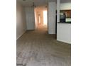 An open-concept living space with neutral carpet, white walls, and a view leading to the kitchen at 2320 Coach Way, Jonesboro, GA 30236
