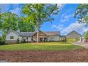 Charming single-story home with a beautiful lawn, mature trees, and inviting curb appeal at 877 Honey Creek Rd, Mcdonough, GA 30252