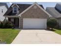 Charming brick home with a two-car garage and well-maintained front lawn and landscaping at 2075 Tussahaw Xing, Mcdonough, GA 30252