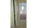 Bright hallway featuring neutral walls and tiled flooring that leads to a carpeted room at 2075 Tussahaw Xing, Mcdonough, GA 30252