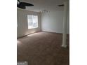 Spacious living room featuring neutral walls, a ceiling fan, and a large window at 2075 Tussahaw Xing, Mcdonough, GA 30252