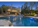 The resort-style backyard features a large pool with a waterfall and a covered outdoor seating area at 113 Regents Sq, Peachtree City, GA 30269