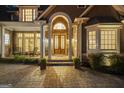 Elegant front entrance with arched doorway, decorative glass doors, stone pillars, and covered porch at 113 Regents Sq, Peachtree City, GA 30269