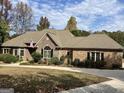 Attractive brick home with stone accents, an American flag, and mature landscaping at 232 Darwish Dr, Mcdonough, GA 30252