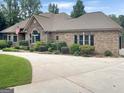 Sprawling single-story home with a circular driveway, manicured landscaping, and a brick and stone facade at 232 Darwish Dr, Mcdonough, GA 30252